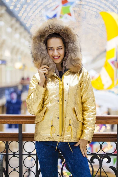 Mulher bonita morena em casaco de pele dourada — Fotografia de Stock