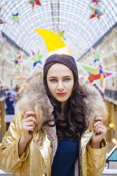 Schöne brünette Frau im goldenen Pelzmantel — Stockfoto