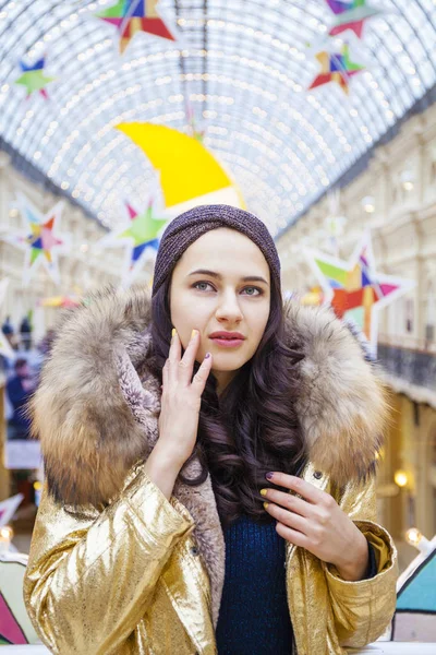 Mooie brunette vrouw in gouden bontjas — Stockfoto