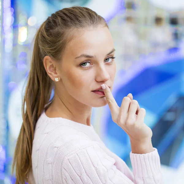 Jonge mooie blonde vrouw heeft wijsvinger lippen breng als teken — Stockfoto