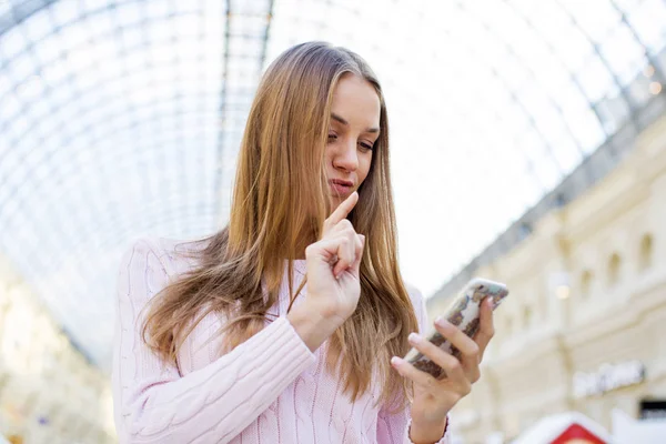 Jeune femme blonde heureuse lisant un message au téléphone — Photo