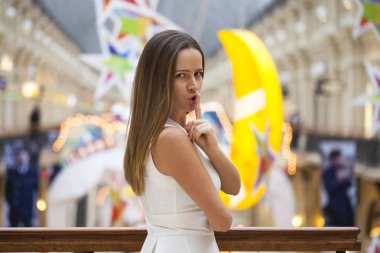 Genç güzel esmer kadın işaret parmağı SIG dudaklarını koydu