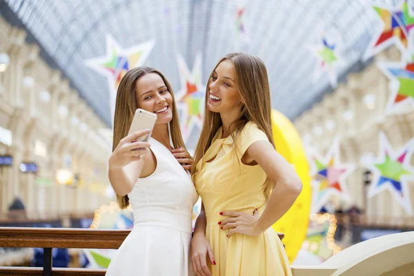 Zwei lächelnde Frauen machen ein Foto von sich mit einem Smartphone — Stockfoto