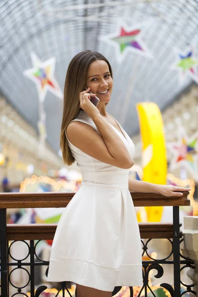 Mujer joven en vestido blanco llamando a un teléfono celular —  Fotos de Stock