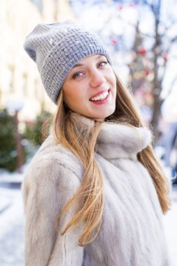 Genç kadın bir mavi örgü şapka ve gri vizon kürk