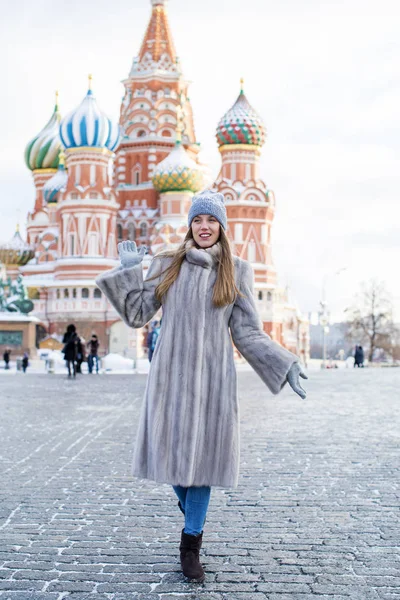 Молодая женщина в голубой вязаной шляпе и сером норковом пальто — стоковое фото