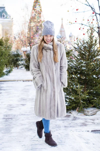 蓝色针织的帽子和灰色貂皮大衣的年轻女子 — 图库照片