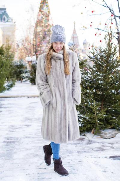 Giovane donna in un cappello a maglia blu e cappotto di visone grigio — Foto Stock