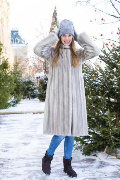 蓝色针织的帽子和灰色貂皮大衣的年轻女子 — 图库照片