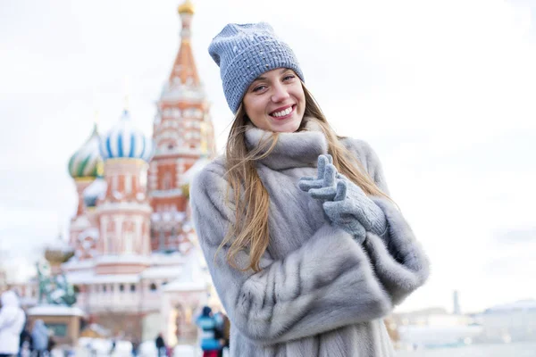 Giovane donna in un cappello a maglia blu e cappotto di visone grigio — Foto Stock