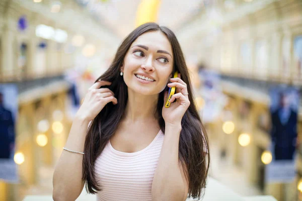 Jeune femme en robe rose appelant sur un téléphone portable — Photo