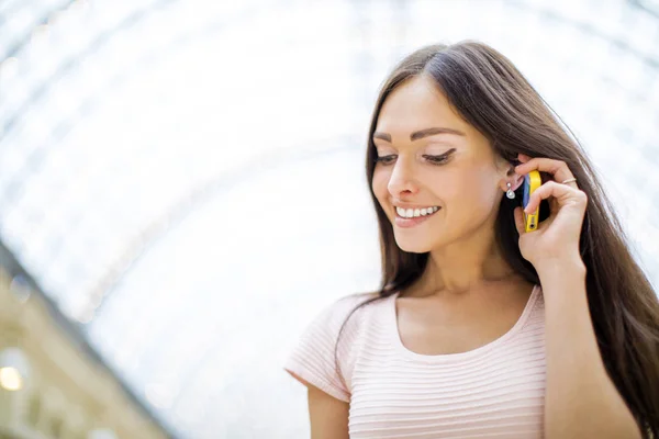 Jonge vrouw in roze jurk op een mobiele telefoon bellen — Stockfoto