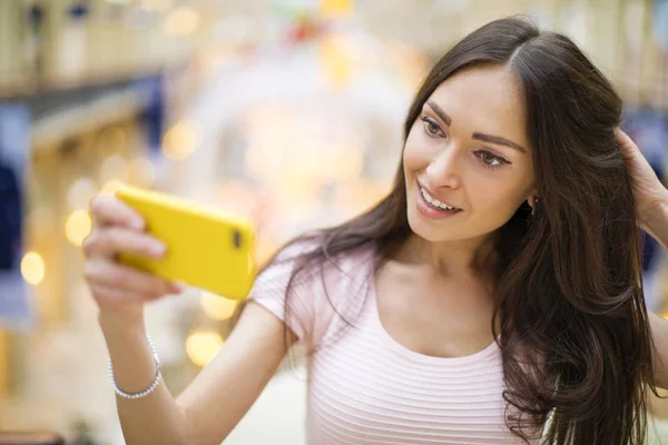 Schöne, lächelnde Frau macht ein Foto von sich mit einem Smartphone — Stockfoto