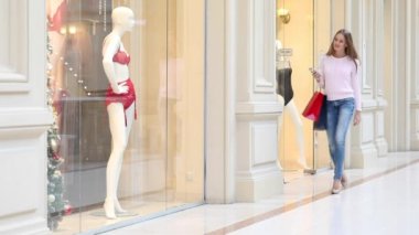 Bazı alışveriş torbaları dükkanda yürüyüş ile sarışın kadın
