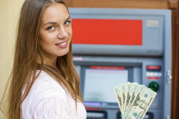 Junge blonde Frau hält einen Bardollar in der Hand — Stockfoto