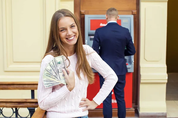 Mujer rubia joven está sosteniendo un dinero en efectivo — Foto de Stock