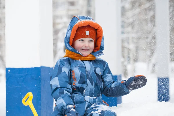 Batole dítě hraje sněhu v zimě. — Stock fotografie