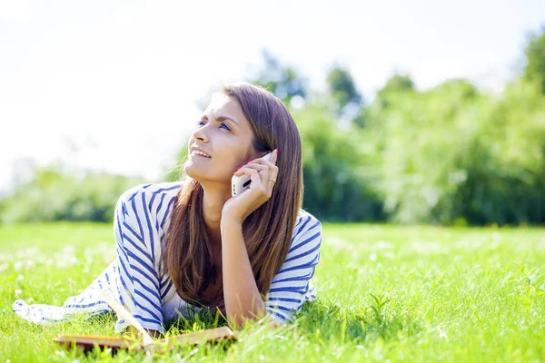 Ung kvinna talar i en mobiltelefon — Stockfoto