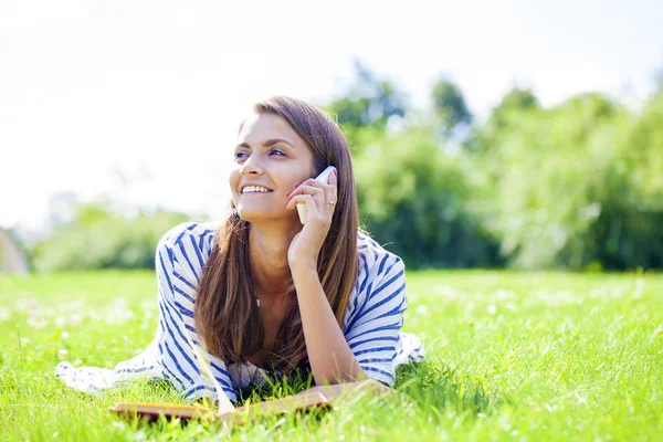 Ung kvinna talar i en mobiltelefon — Stockfoto