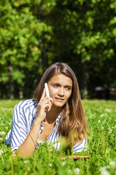 Ung kvinna talar i en mobiltelefon — Stockfoto