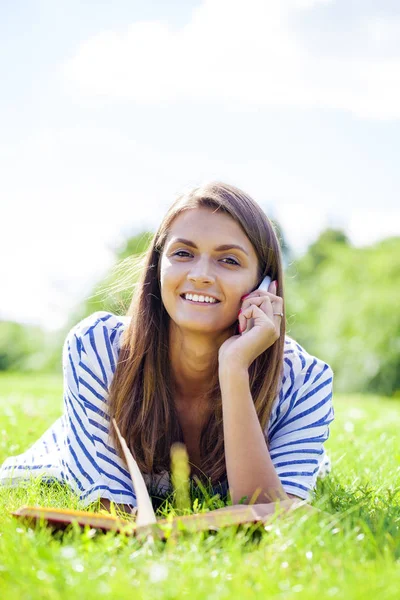 Ung kvinna talar i en mobiltelefon — Stockfoto