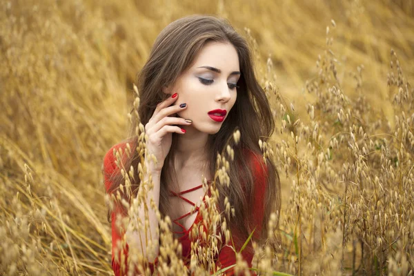 Portrait of a young brunette woman in red dress — Stock Photo, Image