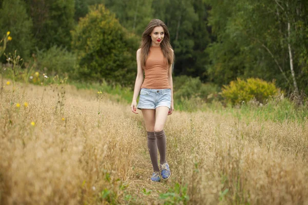 Jovem mulher bonita andando em um campo, verão ao ar livre — Fotografia de Stock