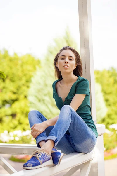 Jovem bela mulher de cabelos castanhos em jeans azuis — Fotografia de Stock