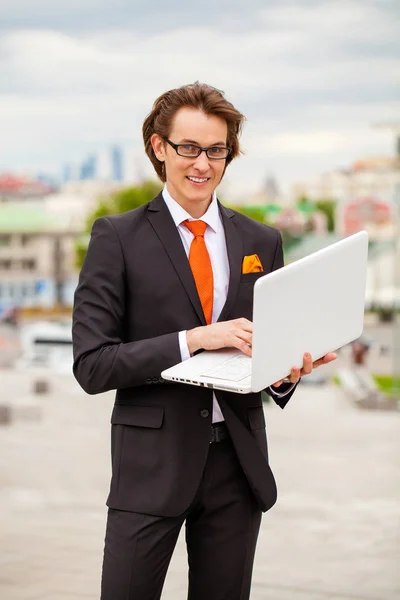 Porträt eines fröhlichen Geschäftsmannes mit Laptop — Stockfoto
