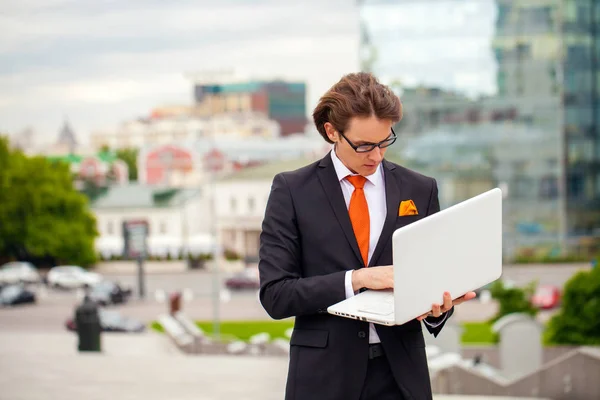 Retrato de um empresário alegre com laptop — Fotografia de Stock