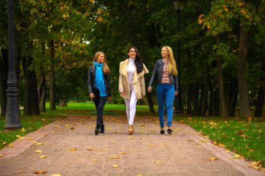 Üç genç güzel kadın parkta yürüyüş