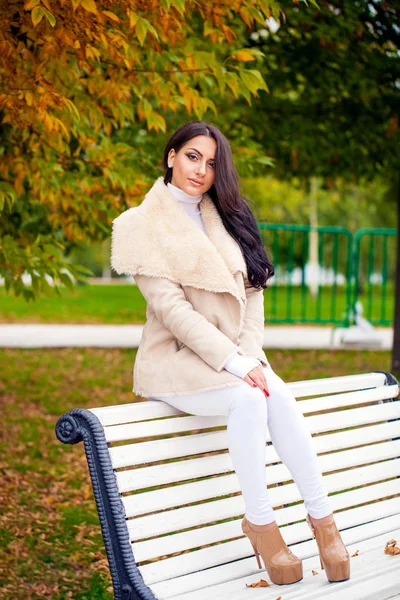 Όμορφες γυναίκες αραβική μελαχρινή σε λευκό sheepskin παλτό συνεδρίαση — Φωτογραφία Αρχείου