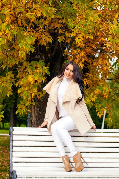 Gyönyörű Arab barna női fehér báránybőr kabátot ülés — Stock Fotó