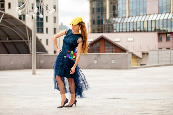 Porträt einer brünetten Frau mit gelbem Hut und blauem Kleid — Stockfoto