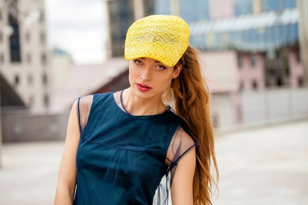 Portrait d'une femme brunnete en chapeau jaune et robe bleue — Photo