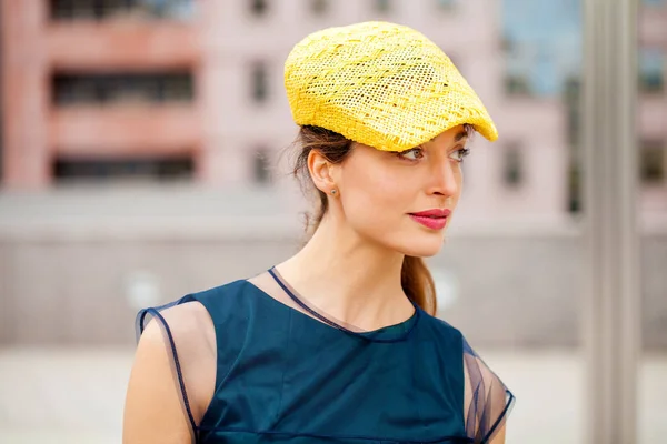 黄色い帽子と青いドレスの brunnete 女性の肖像画 — ストック写真