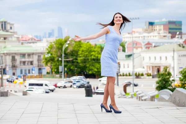 Молодая красивая женщина в синем платье, прогуливаясь по летней улице — стоковое фото
