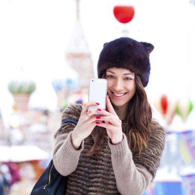 Genç güzel kadın turist üstünde hareket eden telefon fotoğraf çekmek