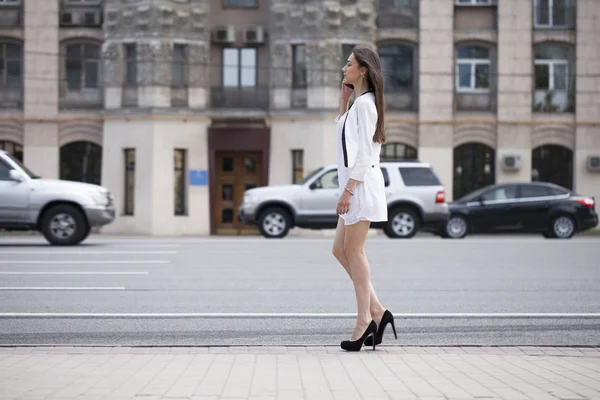 Mulher bonita morena em vestido branco andando na rua — Fotografia de Stock