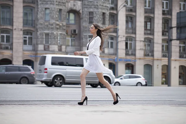 Jovem bela mulher morena em vestido branco andando sobre o str — Fotografia de Stock