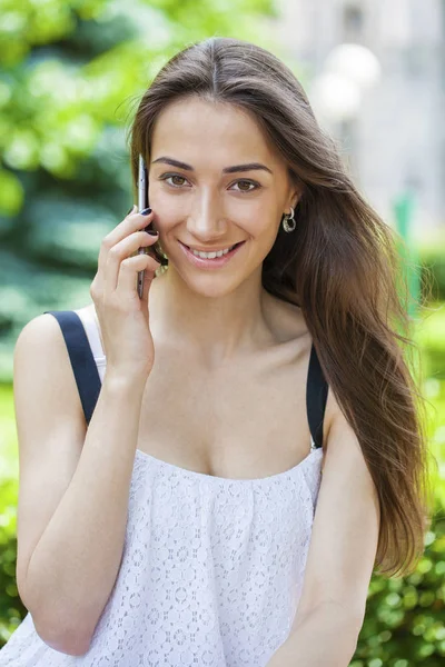 Belle jeune femme brune appelant par téléphone — Photo