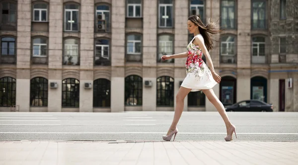 Giovane bella donna bruna in abito da fiori bianchi a piedi — Foto Stock