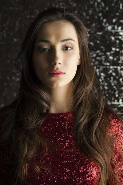 Young brunette woman on dark studio wall background — Stock Photo, Image