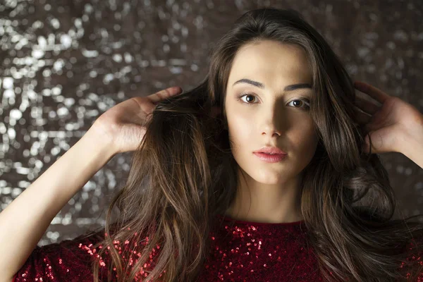 Jeune femme brune sur fond de mur studio sombre — Photo