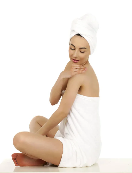Νεαρή γυναίκα τυλιγμένη πετσέτα που απομονώνονται σε λευκό φόντο — Φωτογραφία Αρχείου