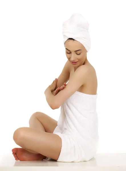 Mujer joven envuelta toalla aislada sobre fondo blanco — Foto de Stock
