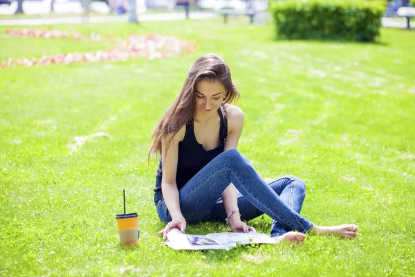 Junge schöne Frau sitzt im Sommerpark — Stockfoto