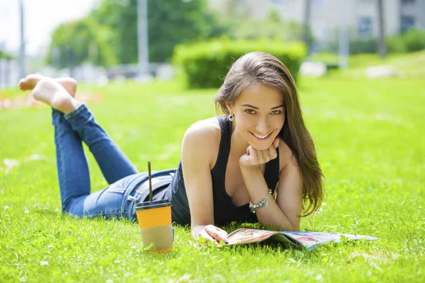 Jeune belle femme assise dans le parc d'été — Photo