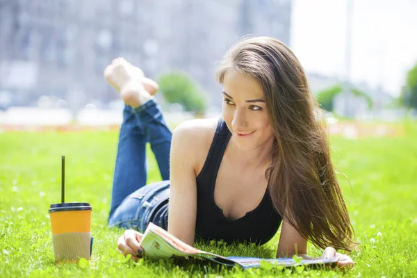 Giovane bella donna seduta nel parco estivo — Foto Stock