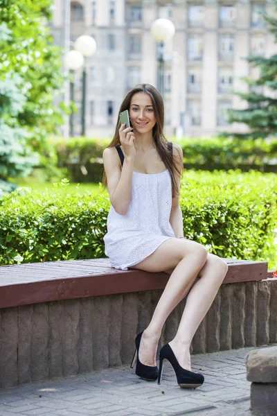 Beautiful young brunette woman calling by phone — Stock Photo, Image